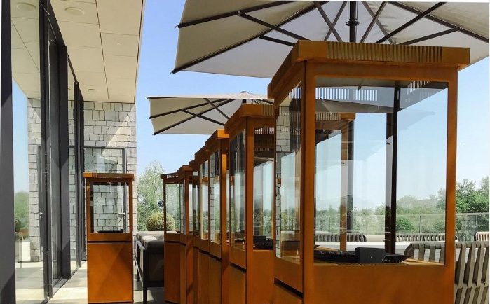 Corten steel patio heaters lined along a restaurant patio